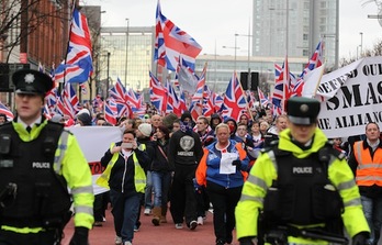 Leales a la bandera británica marchan en las afueras de Belfast ante la custodia de la policía. (Peter MUHLY/AFP)