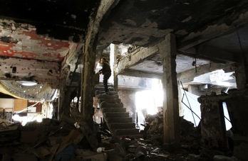 Un hombre armado en un edificio derruido de Al Yarmuk. (Youssef KARWASHAN / AFP)