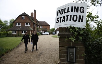 Dos mujeres abandonan un colegio electoral tras depositar su voto. (Adrian DENNIS / AFP)
