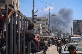 Palestinos divisan una columna de humo desde el centro de Rafah.