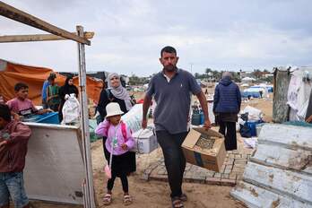 Una familia palestina desmonta su tienda y recoge sus pertenencias para huir del campamento de Rafah.